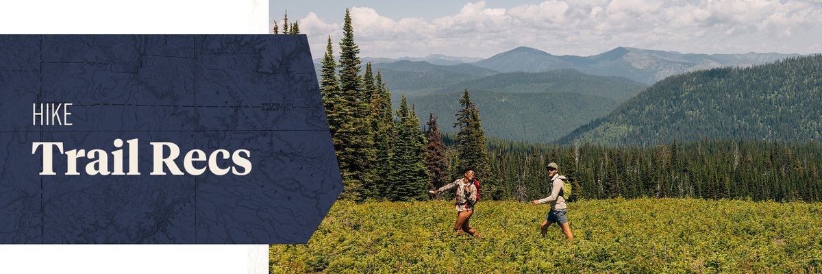 Two people walk through a grassy area. Mountains appear behind them. The words, “hike trail recs” appear next to them.