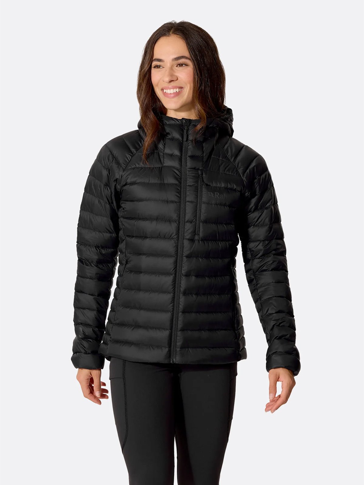 A woman wears the Rab Microlight Alpine jacket.