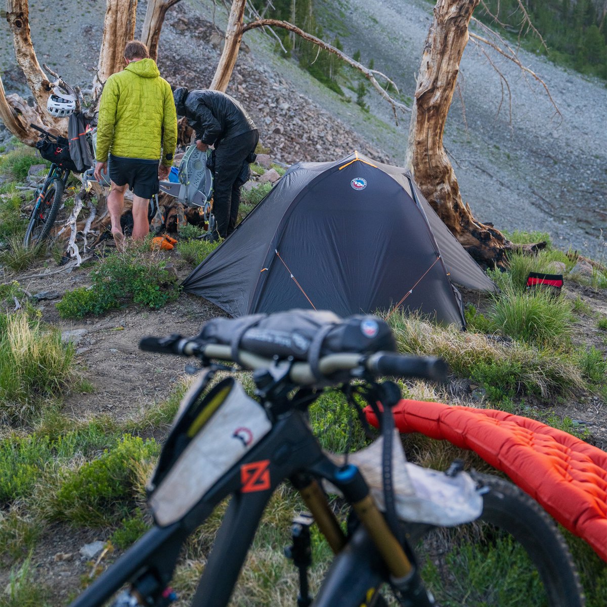 A closeup of a bike with the Copper Spur Bikepacking tent set up in the distance.