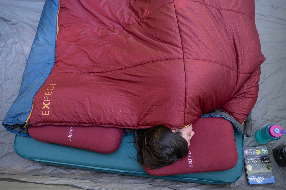 Woman sleeps comfortably on ground with the MegaMat.