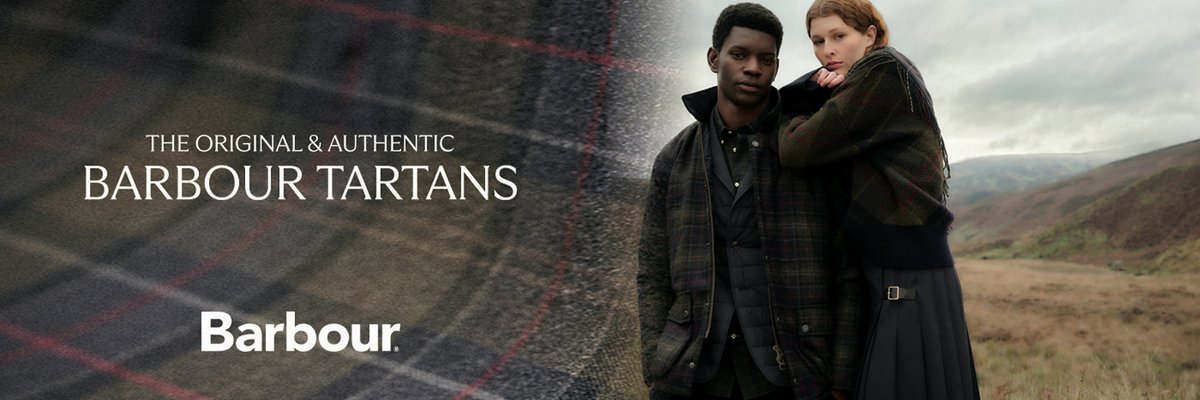 Two models wear Barbour plaid outerwear on a misty hillside, one in a quilted jacket, the other draped in a fringed wool wrap. Overlaid text reads, "The Original and Authentic Barbour Tartans". Featuring the Barbour logo.