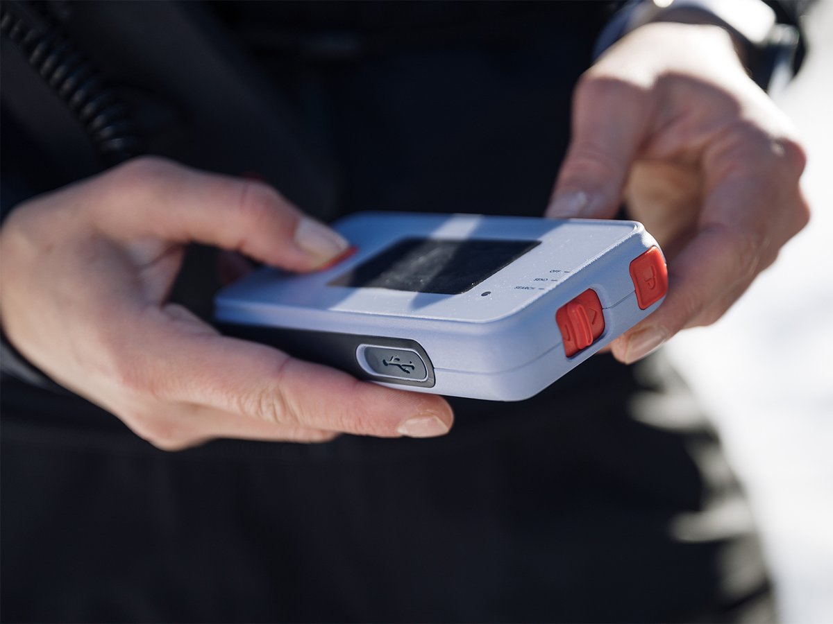 Hands holding a Nivia 3D Finder with the USB-C port visible.