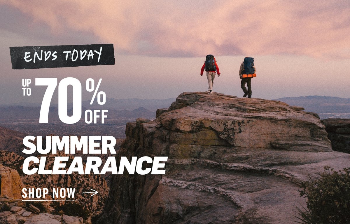 Two backpackers standing on a desert rock formation at dusk. Summer Clearance — ends today — up to 70% off.