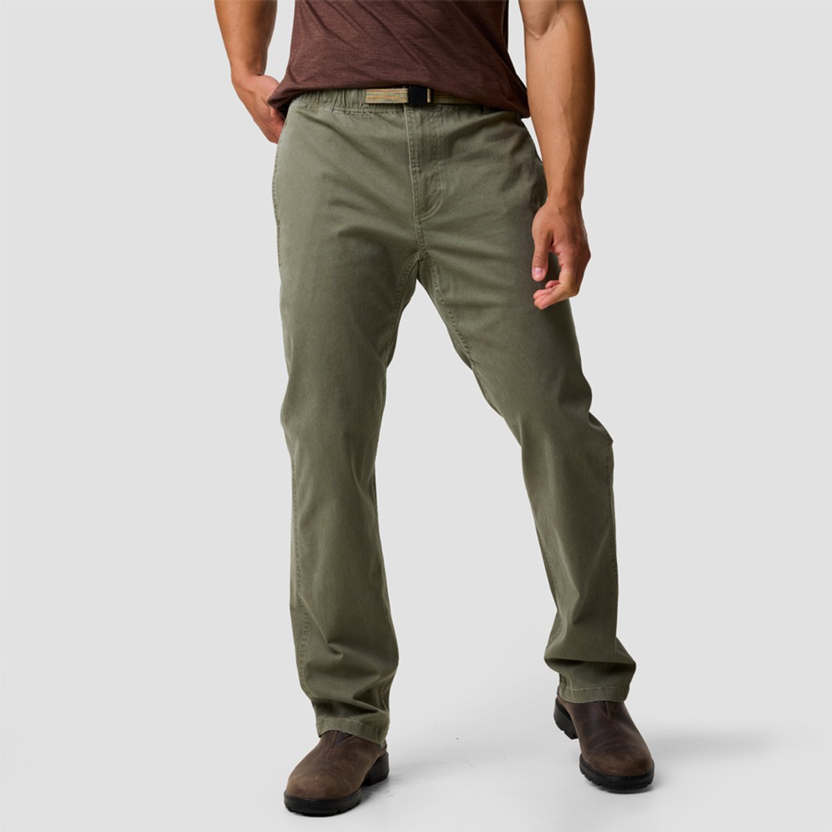 A man wears the BGA Daily Venture Pant, paired with a brown belt and brown boots on a white background.