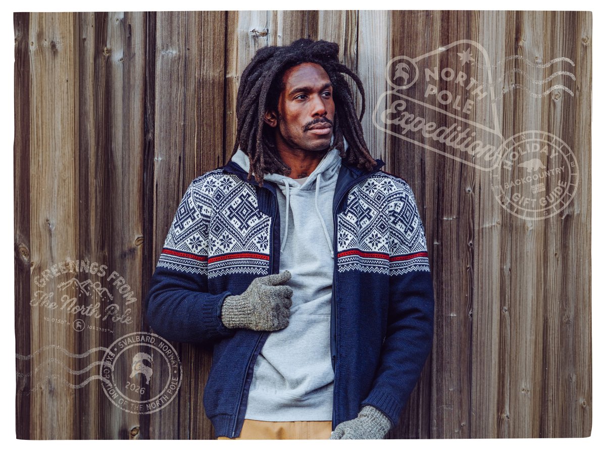 Person in a Nordic-pattern knit jacket and gloves leaning against a wood wall, with “North Pole Expedition” stamps.