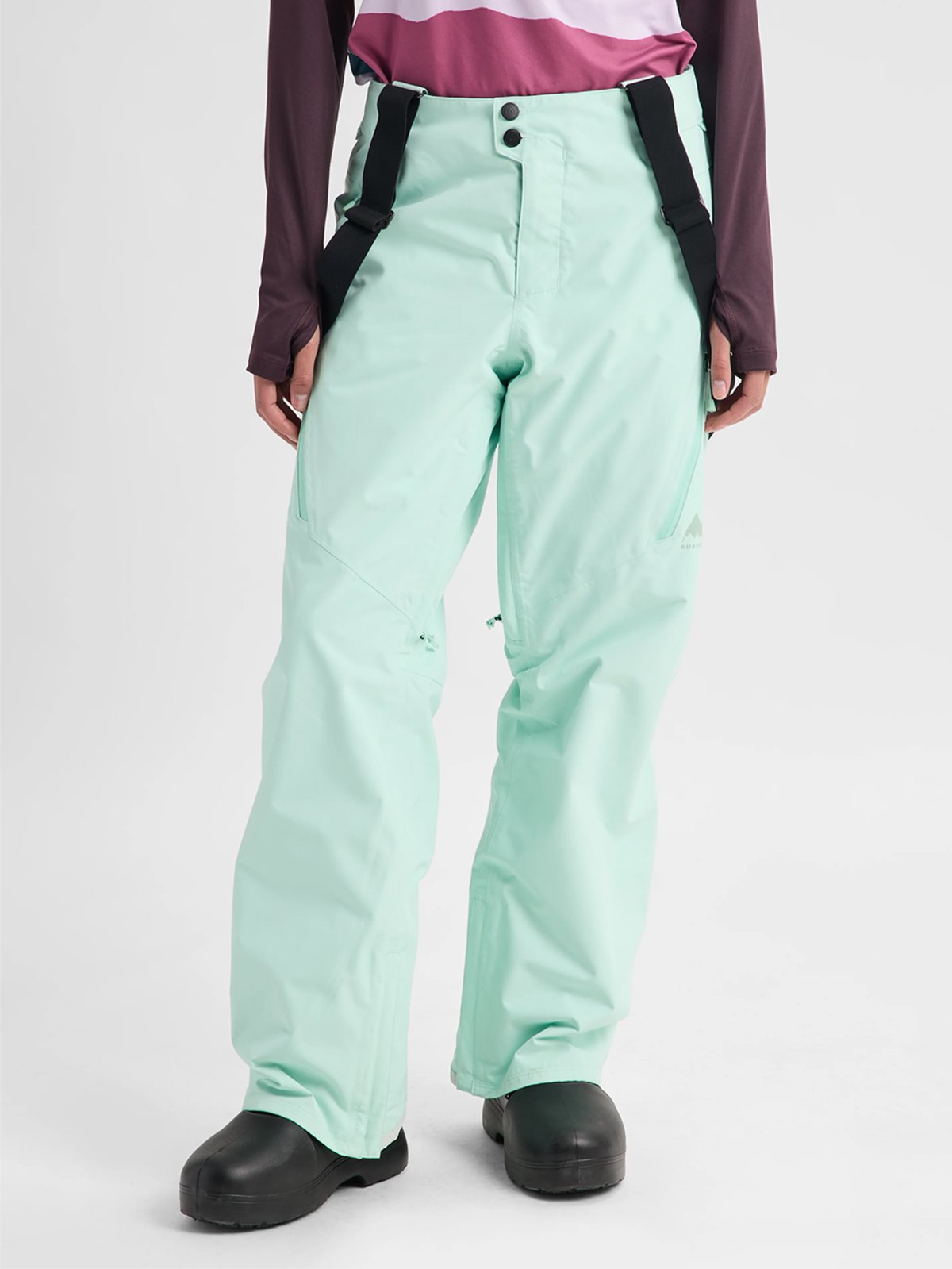 Women's mint green ski pants with black suspender straps and waterproof fabric for winter sports and snow activities.