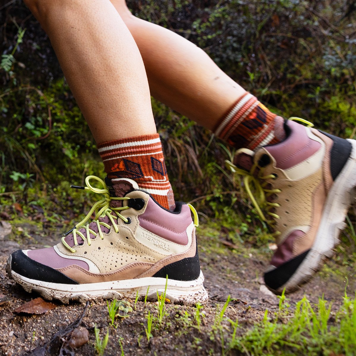 A person hiking on a damp trail wears Vibram-equipped Merrell Speed Solo hiking boots.