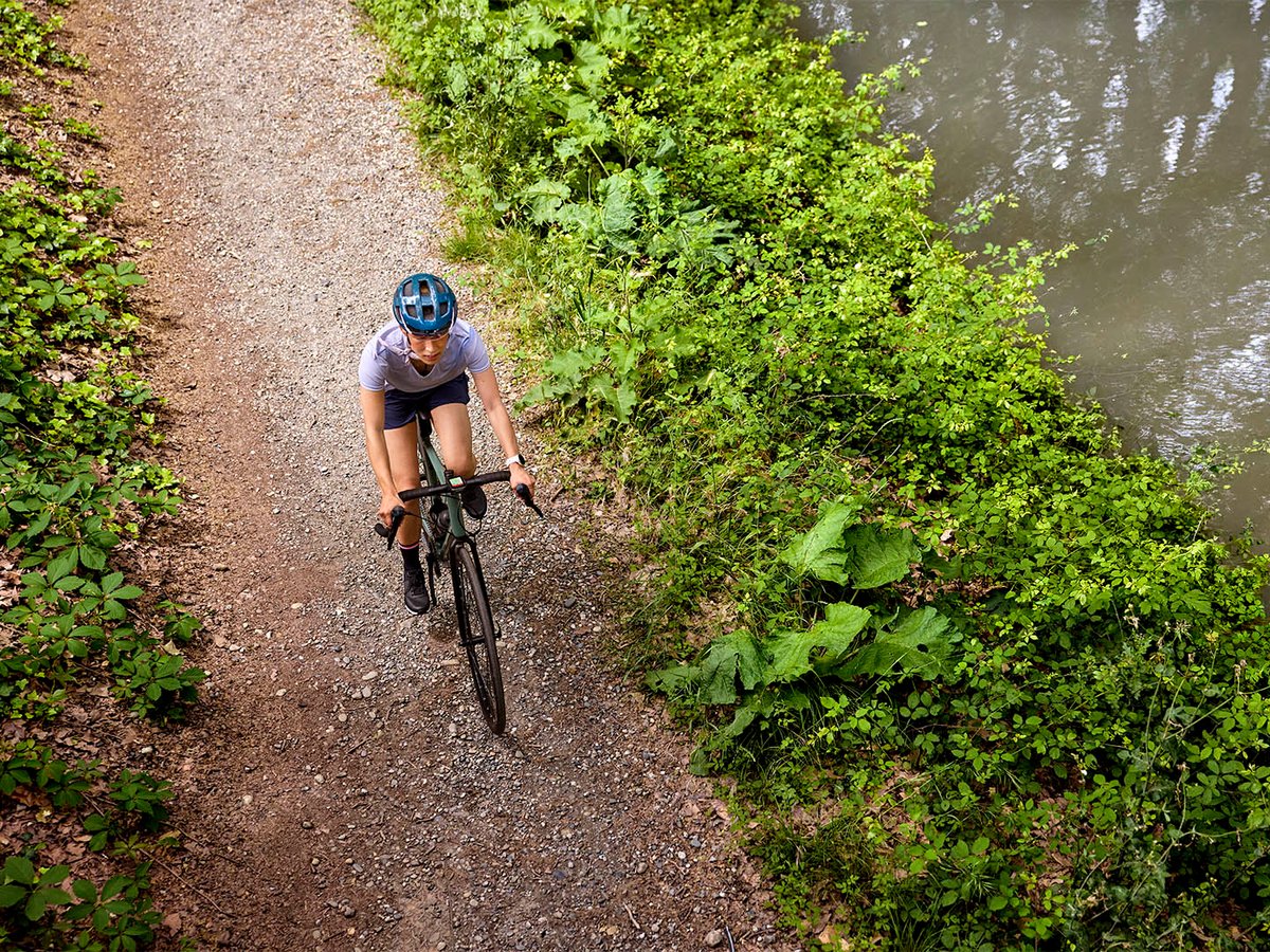 Cyclist riding a gravel path beside a canal