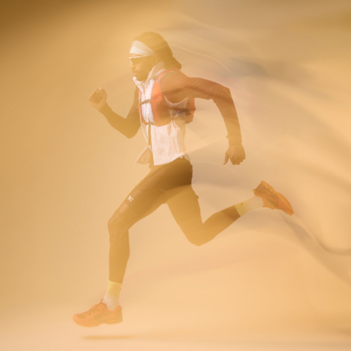 A runner makes a stride with motion blur effect on a gold background. 
