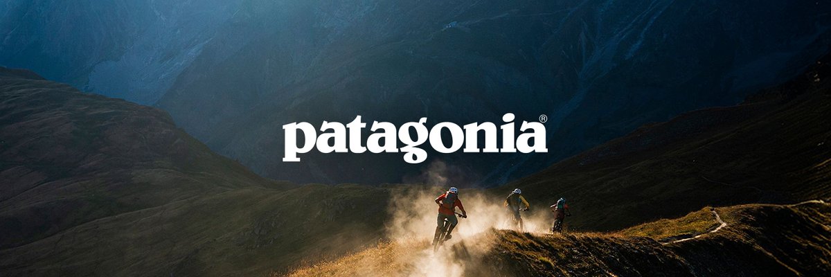 Three mountain bikers ride down a dusty hill. Patagonia's logo is across the image.