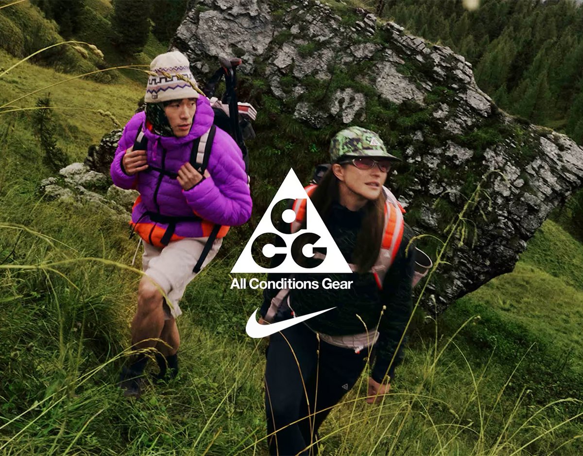 Two people hiking up a hill wearing backpacks with ACG and Nike logo overaly.