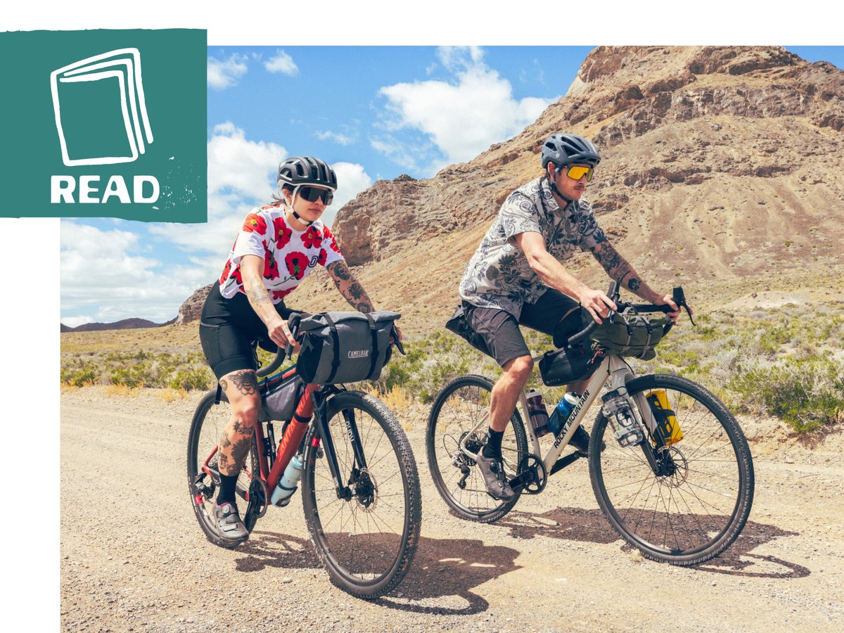 A pair of bikepackers on a mountainous dirt road with a “Play” button in the top left corner.
