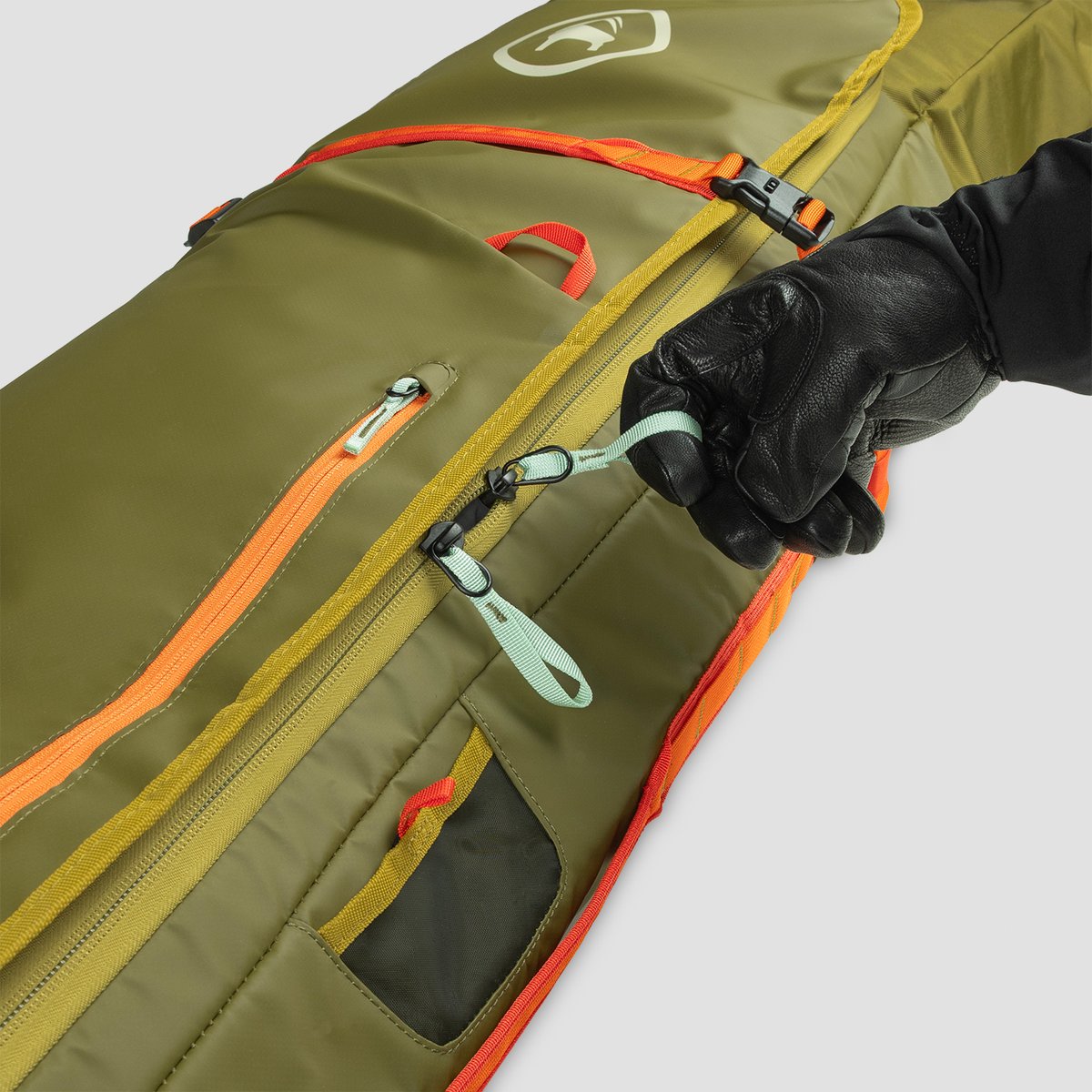 A gloved finger easily slides through the zipper pull loop on the Cottonwoods Double Ski & Snowboard bag.