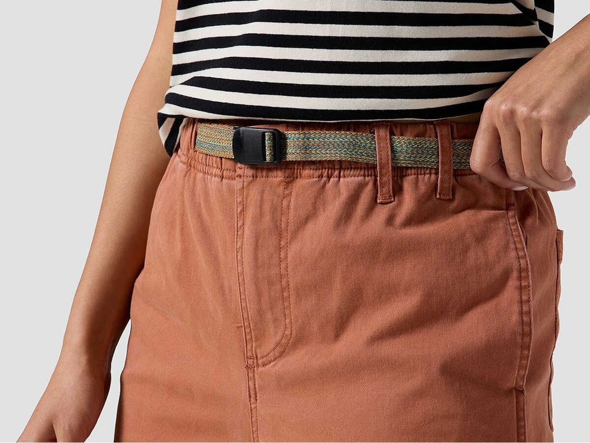 Close-up of front of waistband of rust colored pants with integrated webbing belt.