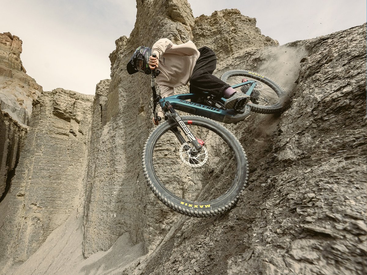 A downhill rider speeding down a steep, gravely trail on a Santa Cruz eMTB.