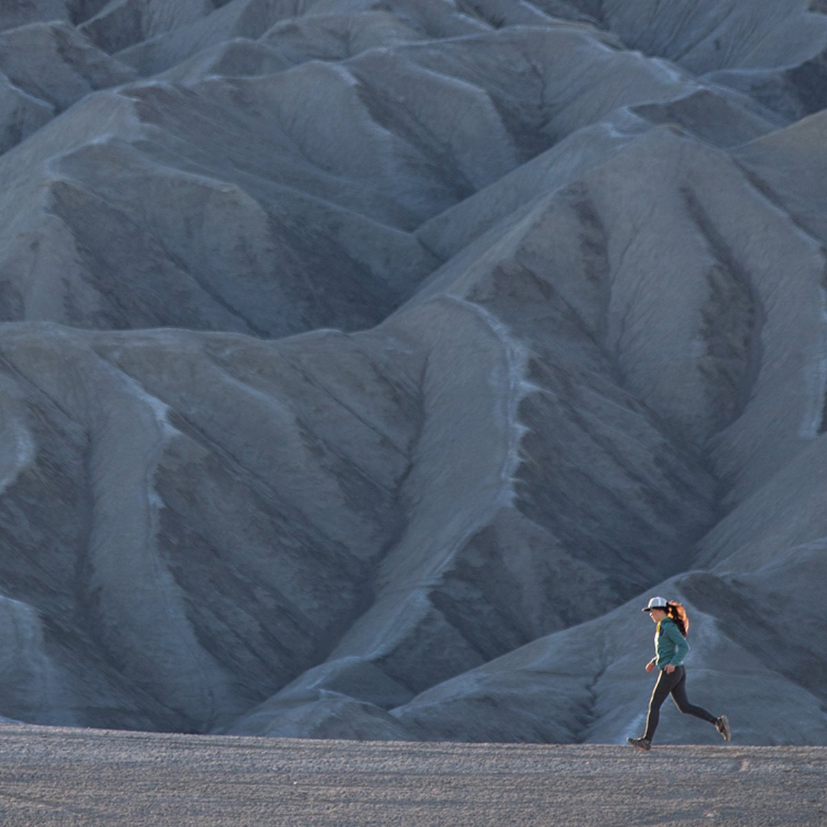 A woman pulls off her blue Patagonia puffy.