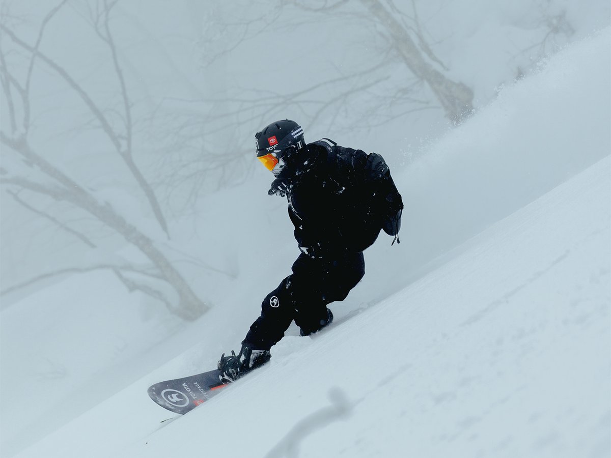 Snowboarder carving down a slope.