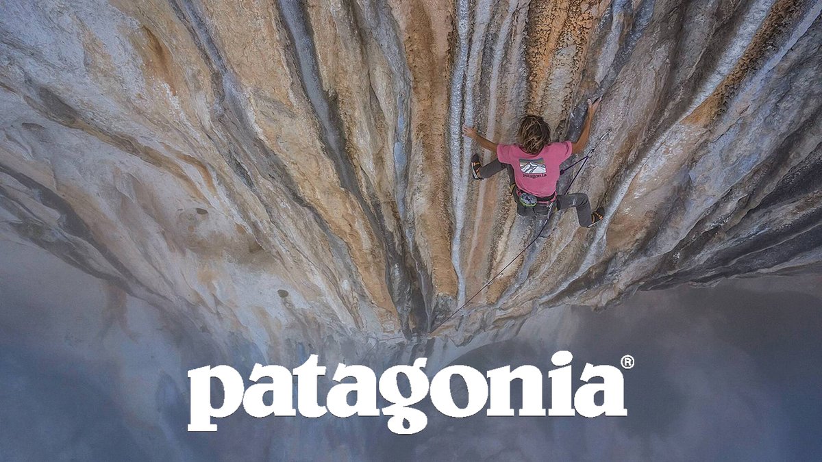 Climber climbing a crag with mist below and Patagonia logo overlay.