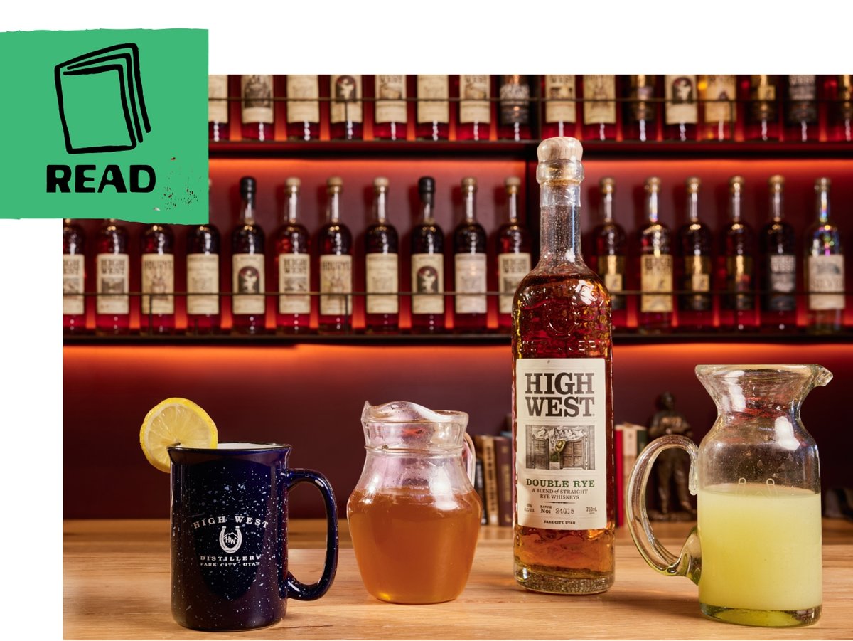 A bar countertop displays a mug with a lemon wheel, a glass pitcher of honey, a bottle of High West Double Rye, and a glass jug ginger juice. A green flag includes an illustration of a book and the word “read.”