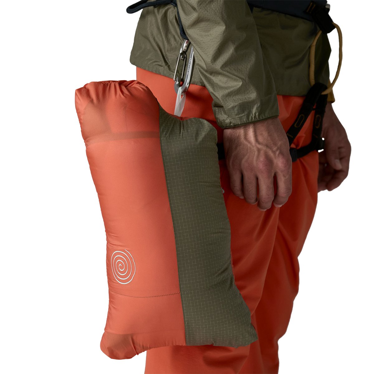 Person wearing climbing harness with puffy parka jacket packed into it's own stuff pocket and cipped to their harness.