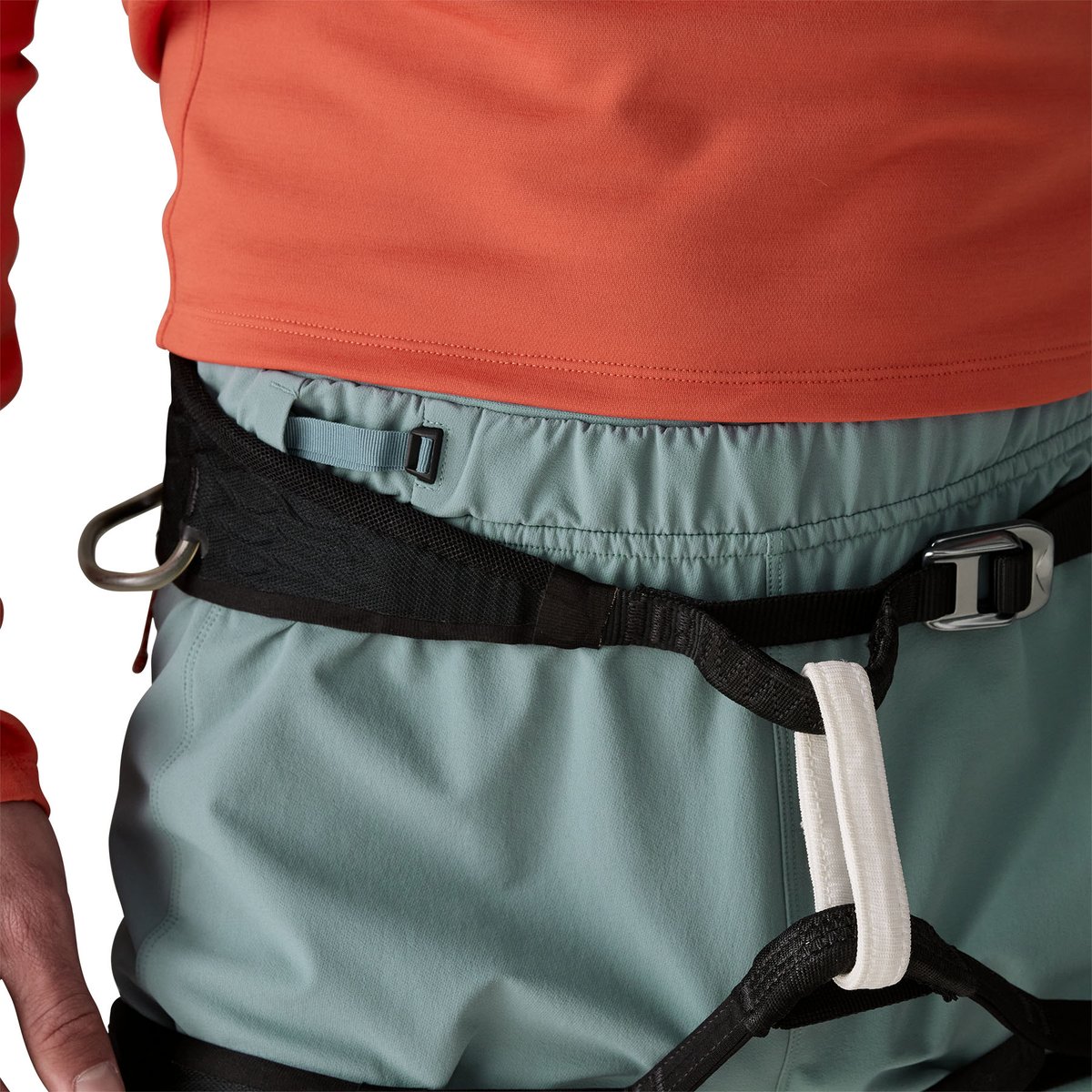 Close-up of climber wearing Free Wall climbing pants with cinched waist and harness over top.