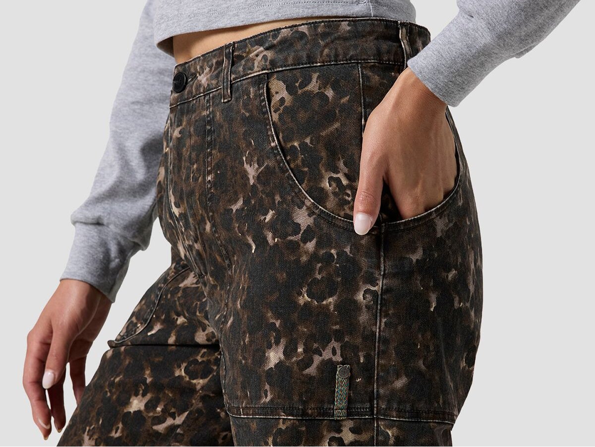 Side view of a person wearing patterned pants, hand resting in the back patch pocket.