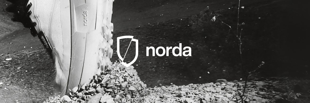 Close-up of a norda trail running shoe kicking through gravel on a rugged trail, featuring the norda logo against a black and white backdrop.