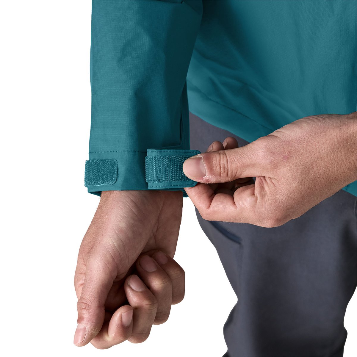 A man adjusts the cuffs on his Torrentshell using the self-fabric hook-and-loop closures