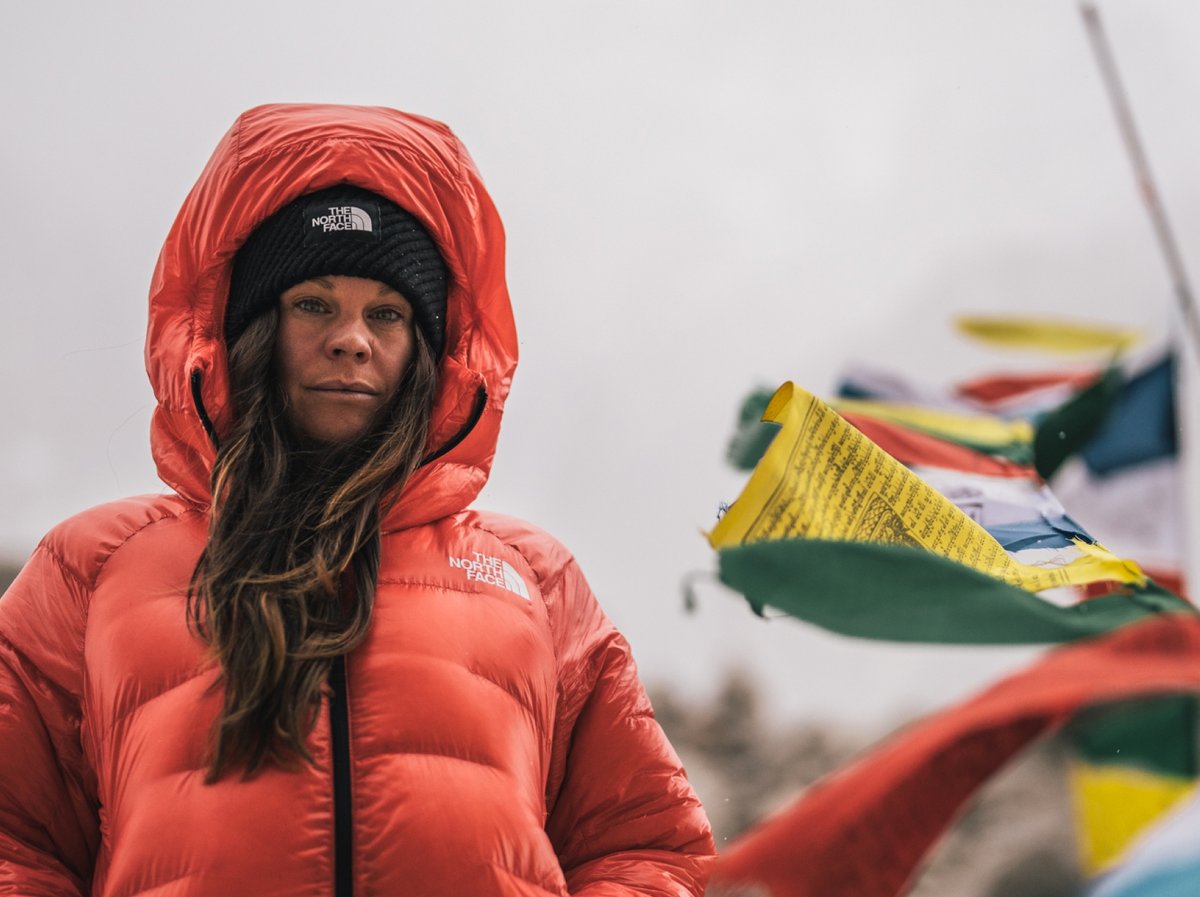 A woman warms her hands in her puffy jacket.