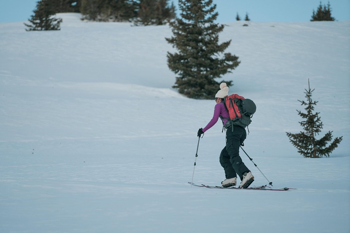 Skier skinning uphill with avypack on.