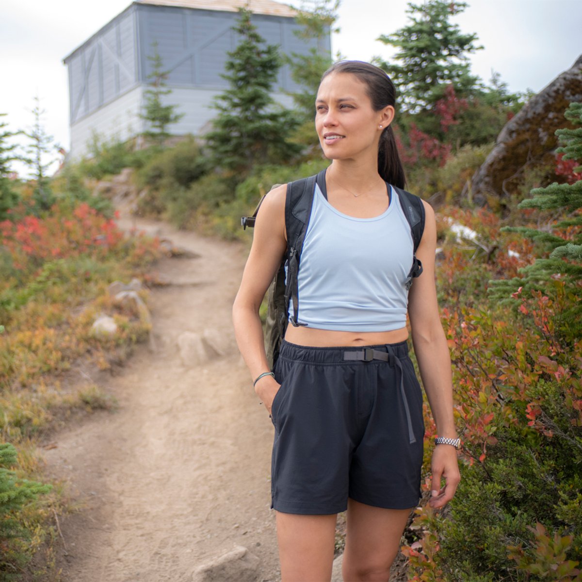 A woman wearing Ferrosi pants stands on a trail.