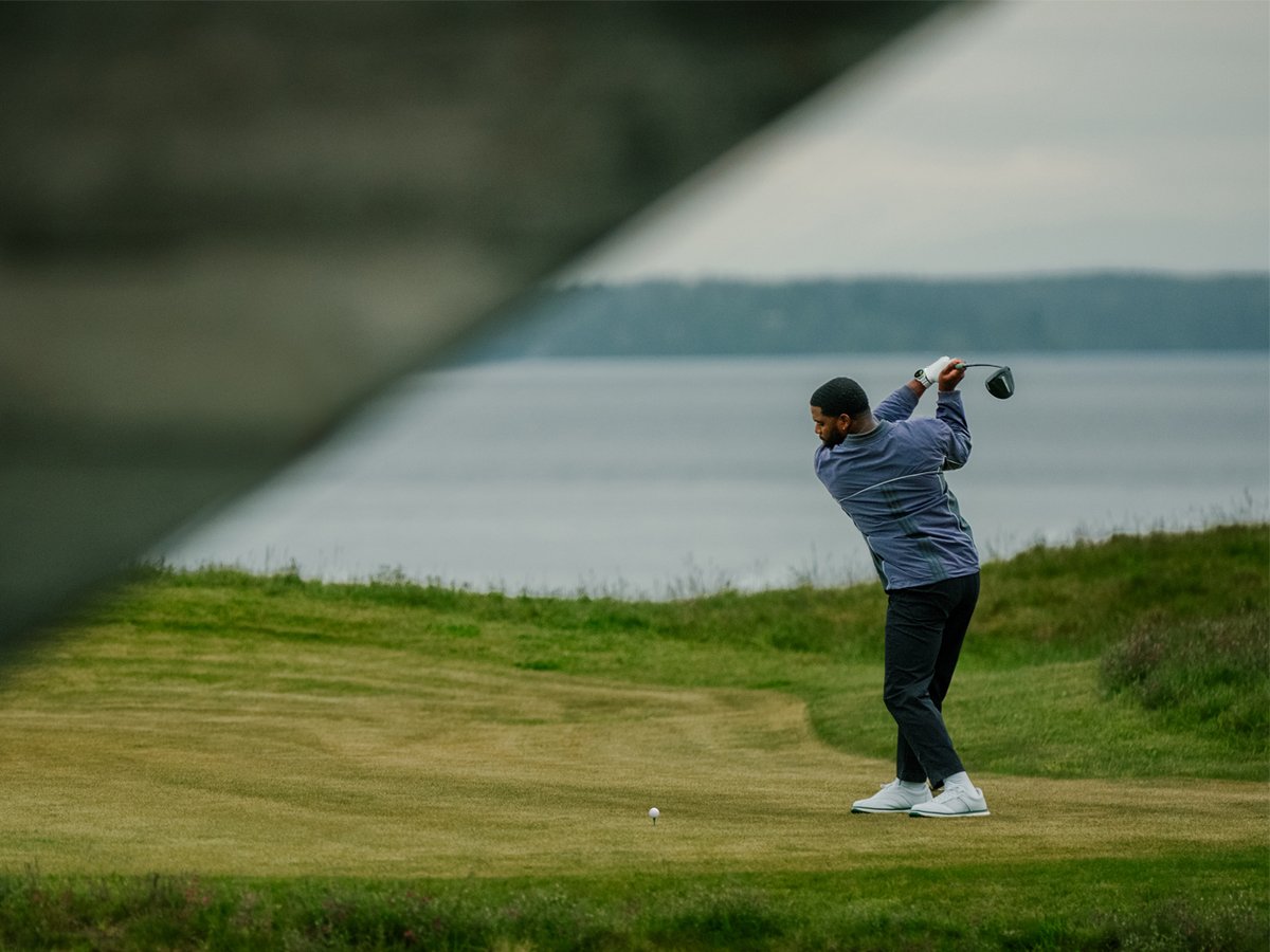 A man swings at a golf tee