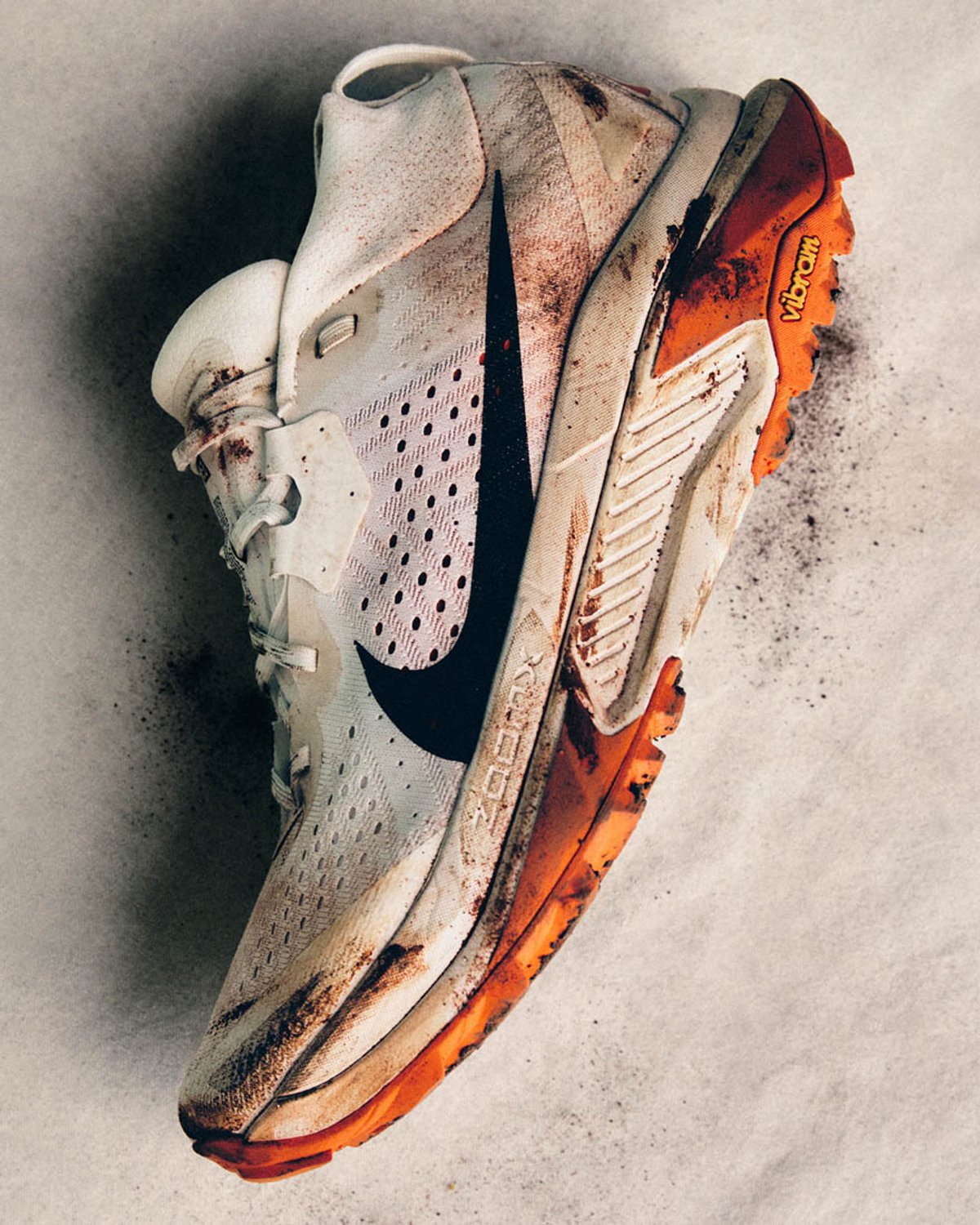 Nike ACG Zegama shoe laying on it's side with some dirt on it.