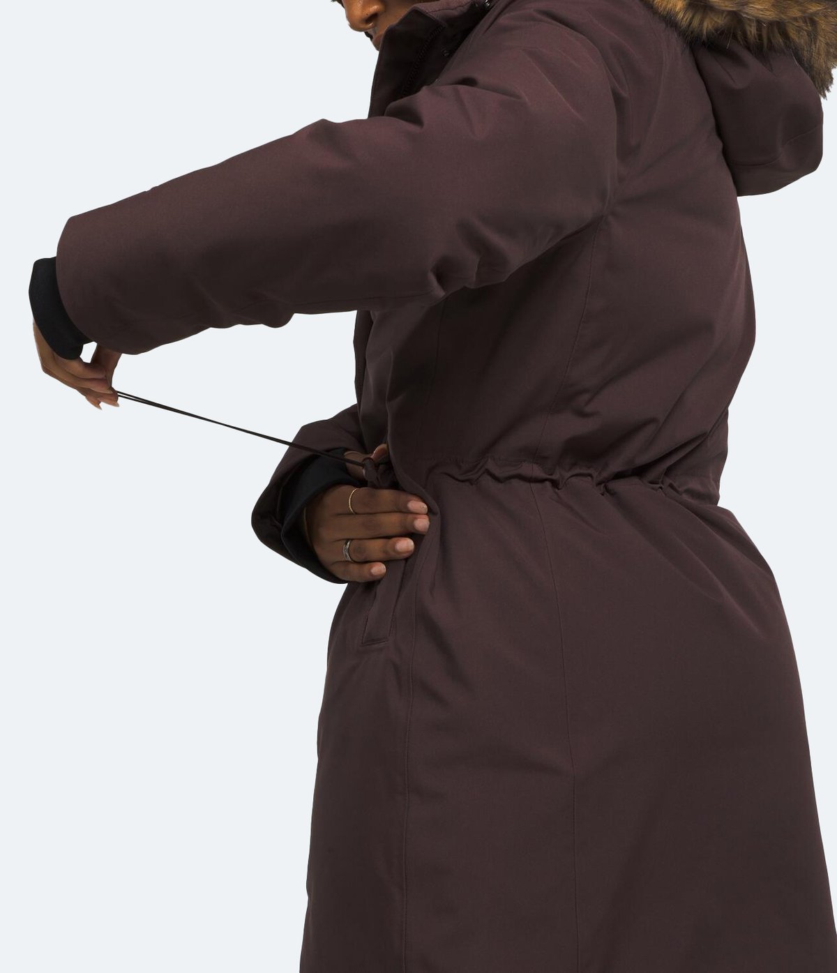 A woman pulls the interior shockcord of the Arctic Down Parka