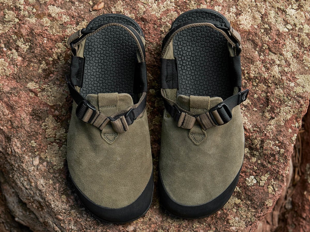 Top-down view of two Bedrock Mountain Clogs on red rock showing hexagonal 3D-textured footbed surface and 3-point strap hardware