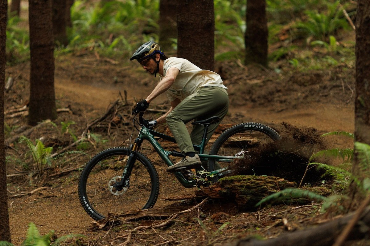 Rider ripping around a corner on a downhill dirt trail.