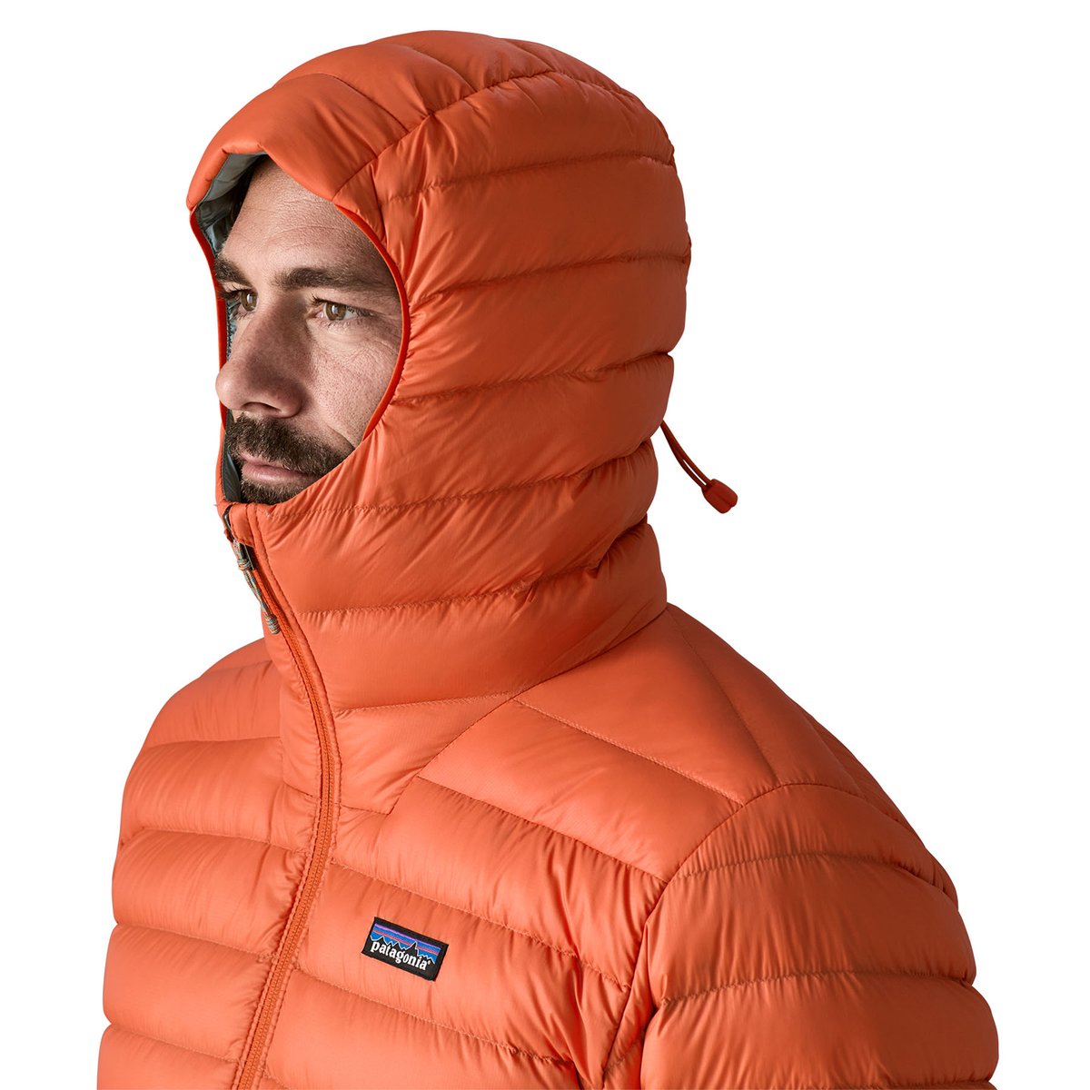 A man wears the Patagonia Down sweater with the hood over his head and lower mouth. 