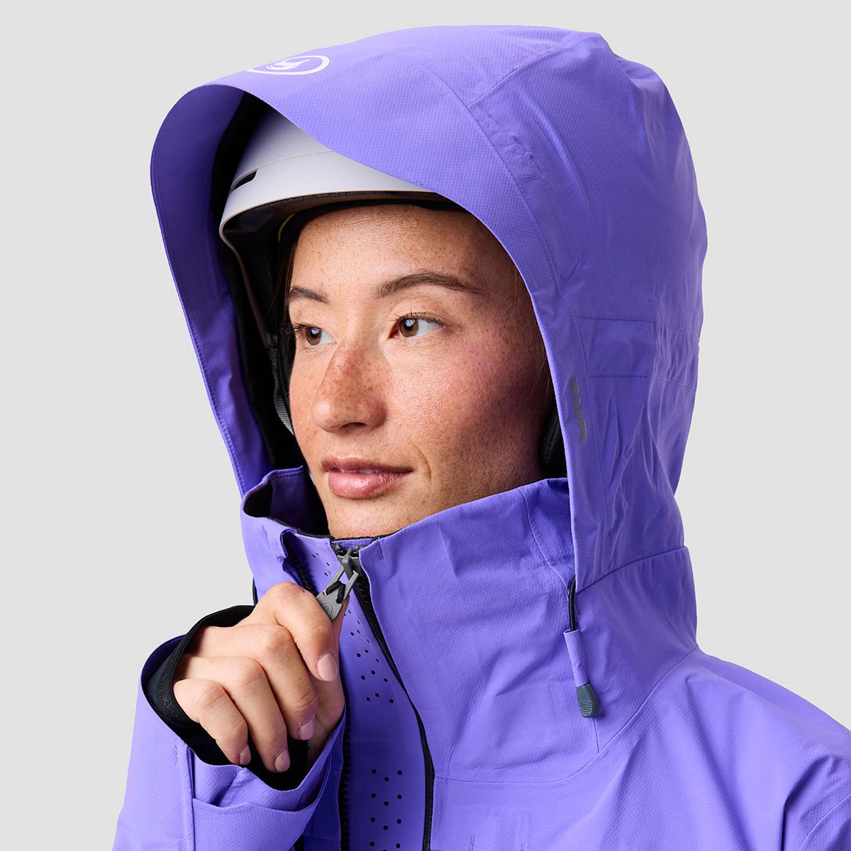 Person zipping up Cotonwoods LT ski jacket with hood up.
