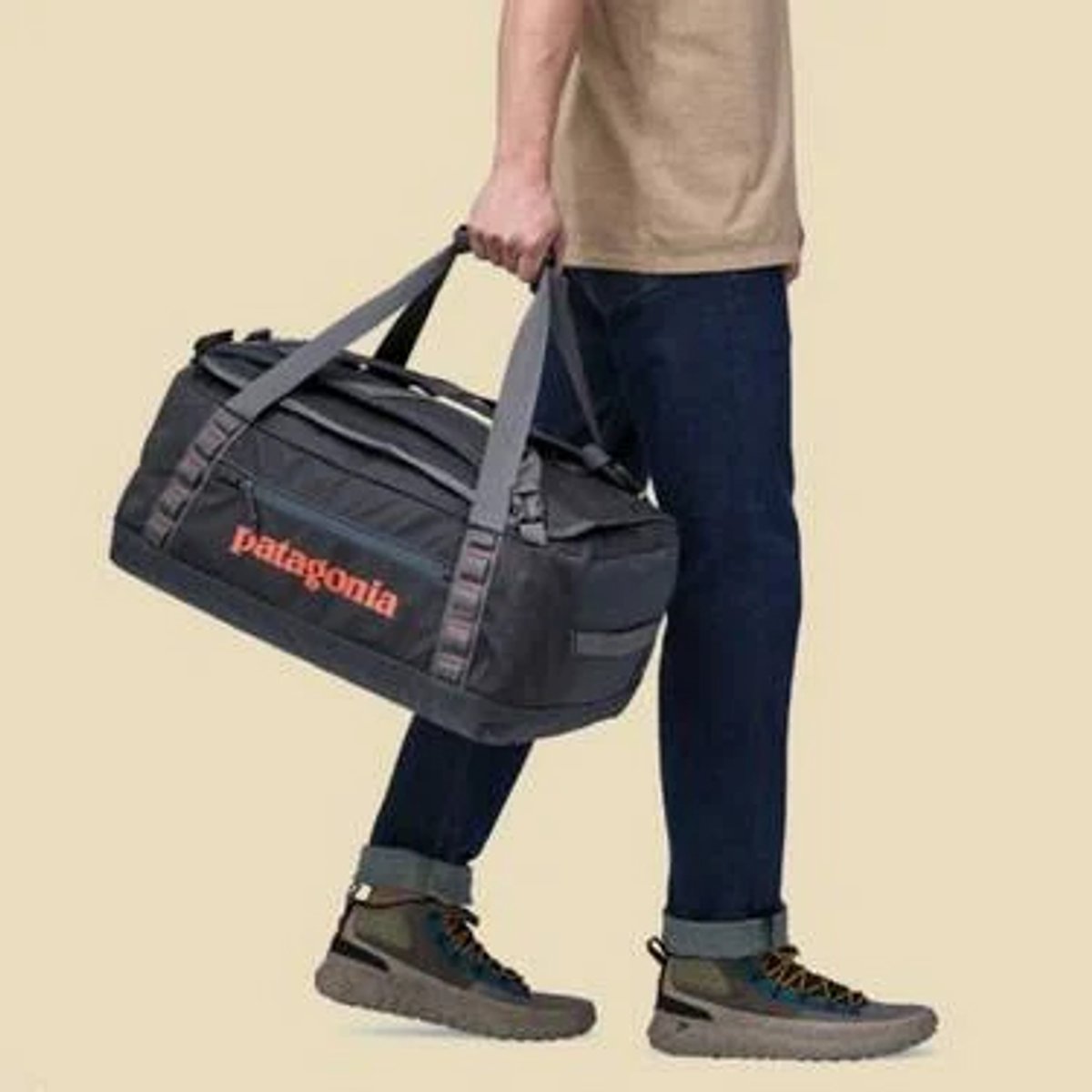 A person walking, carrying a Black Hole Duffel 40L