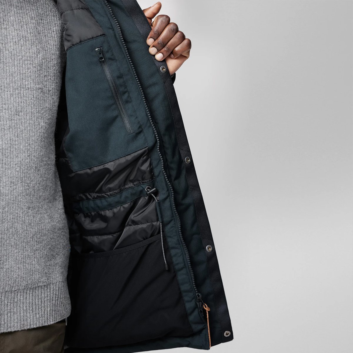 A man shows the front interior of the Fjallraven Nuuk Lite parka.