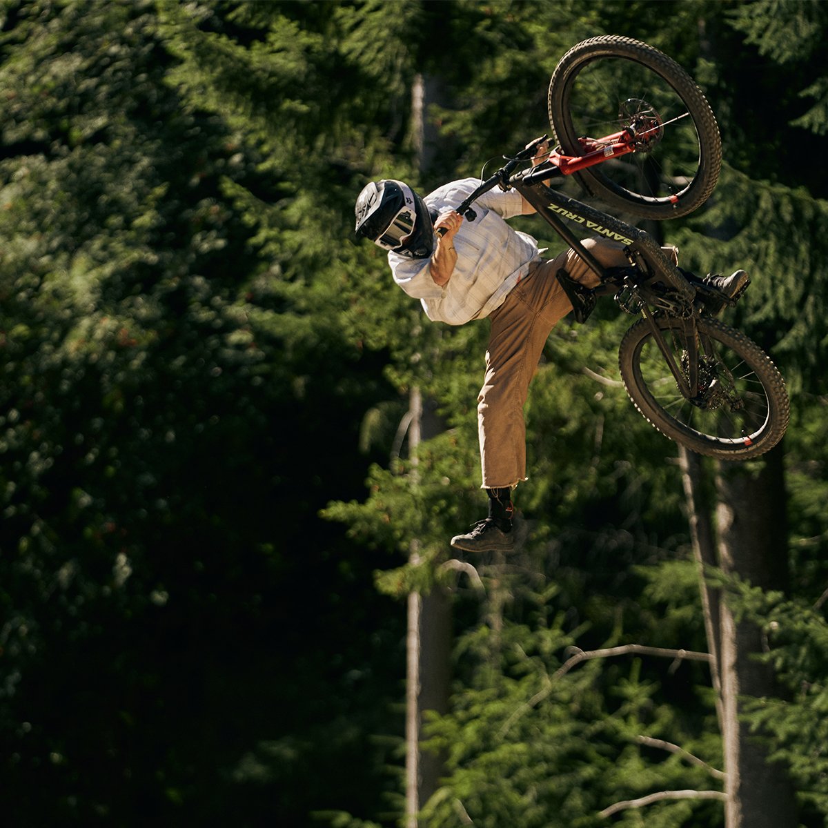Rider gettig air on the Santa Cruz nomad with pine tress in the background.