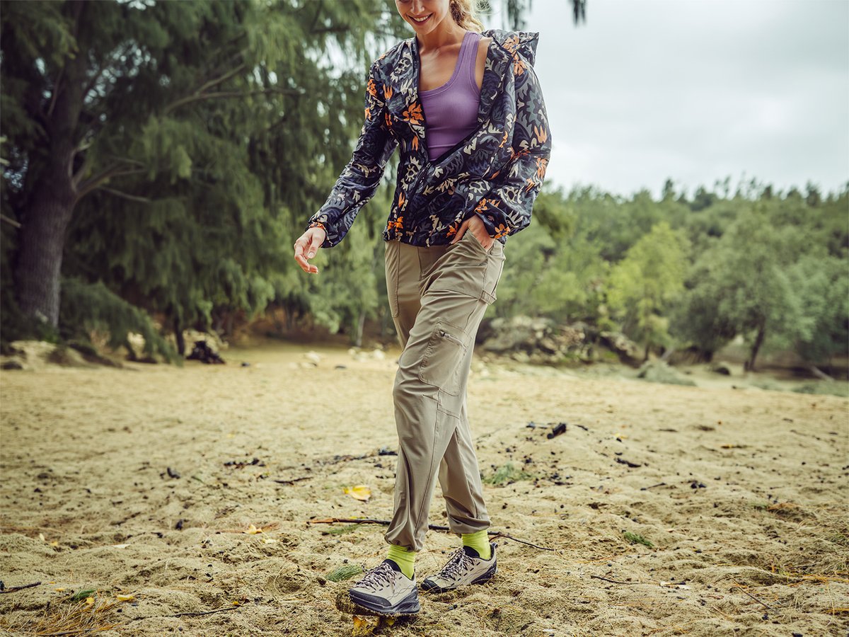 Person wakling across a sandy beach with foilage in the background wearing ripstop shorts.