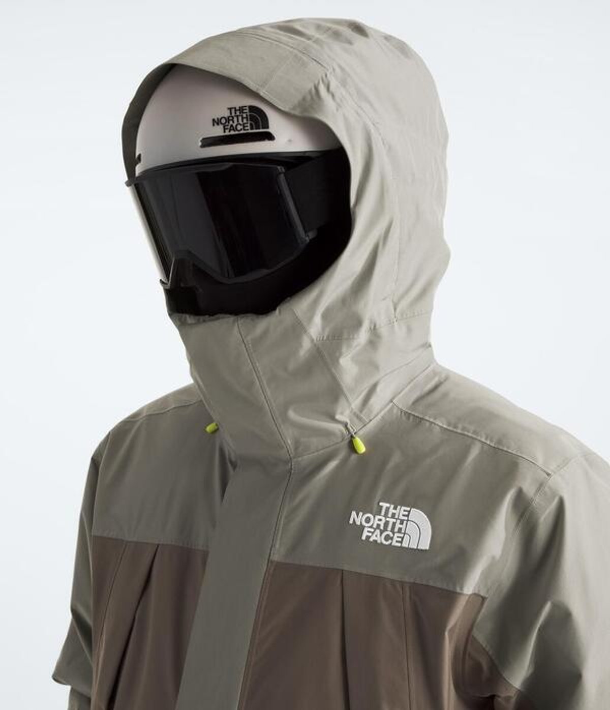 Person wearing jacket with hood up over helmet.