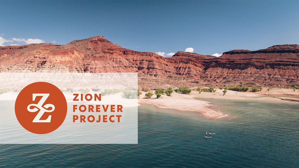 Zion Forever Project logo overlay of image od red rock mountains behind a blue lake with paddleboarders on it.