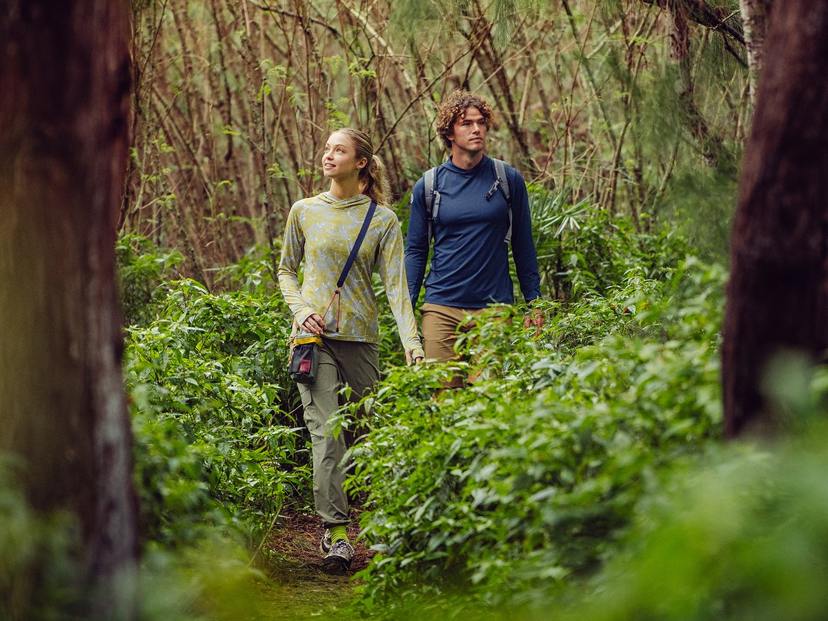 Two people hikging through dense rainforest wearing ripstop bottoms.