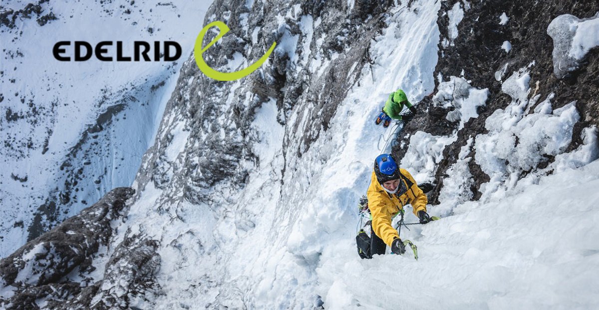 A ice climber in a yellow jacket ascends a frozen waterfall using ice axes, while another climber in green scales the icy rock face above.