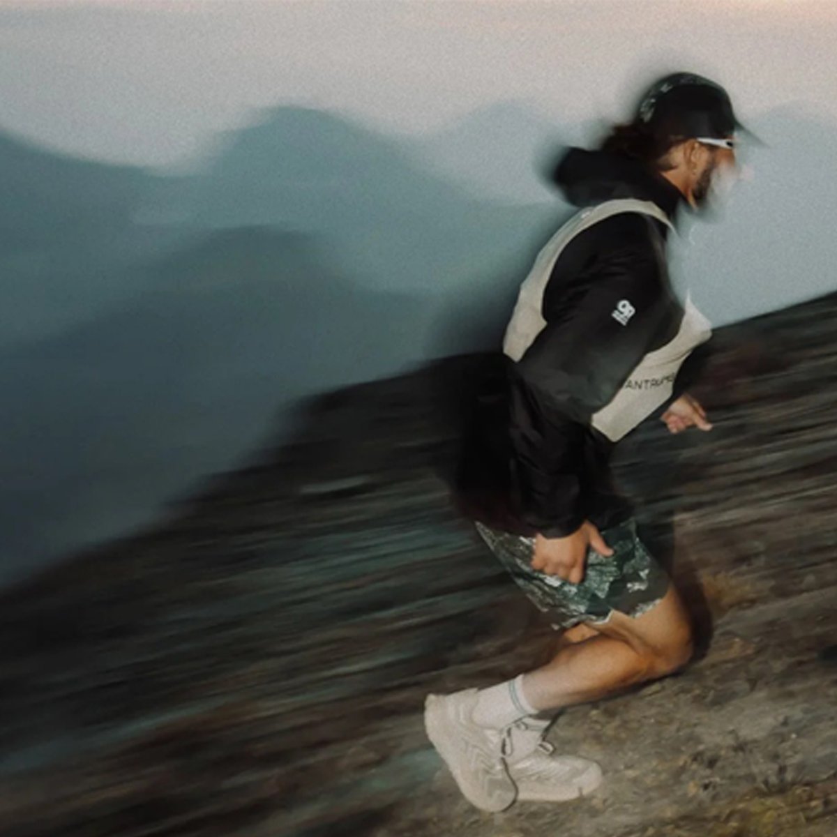 A man wearing Helium Ultralight runs up a mountain trail