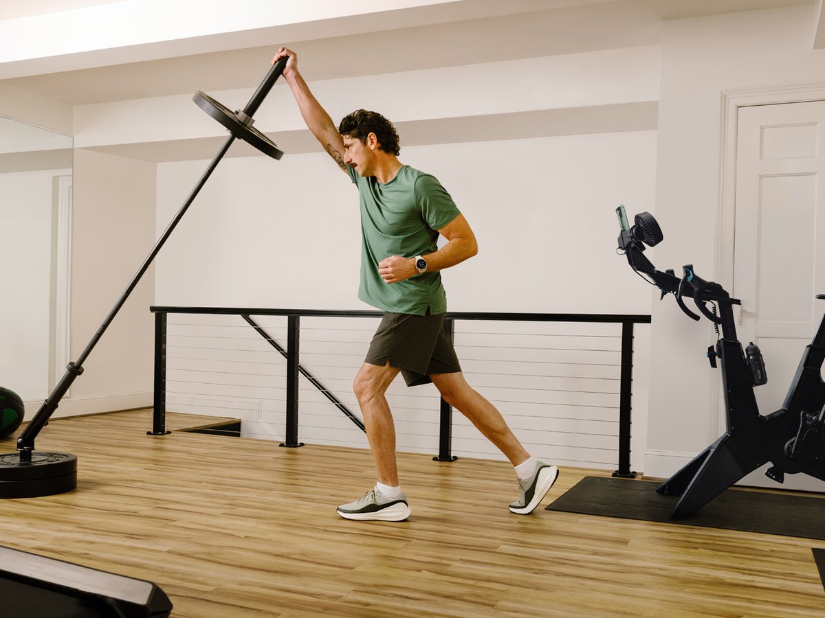 A man works out in a gym, working on his arms for his golf swing.
