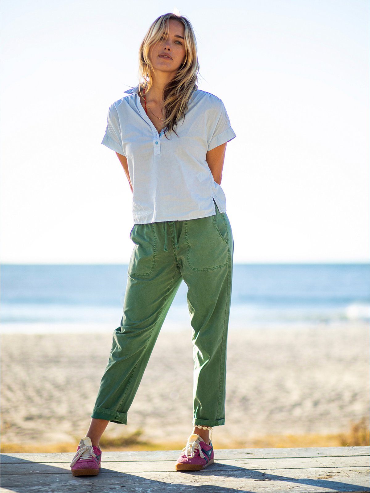 A woman stands on a beach.