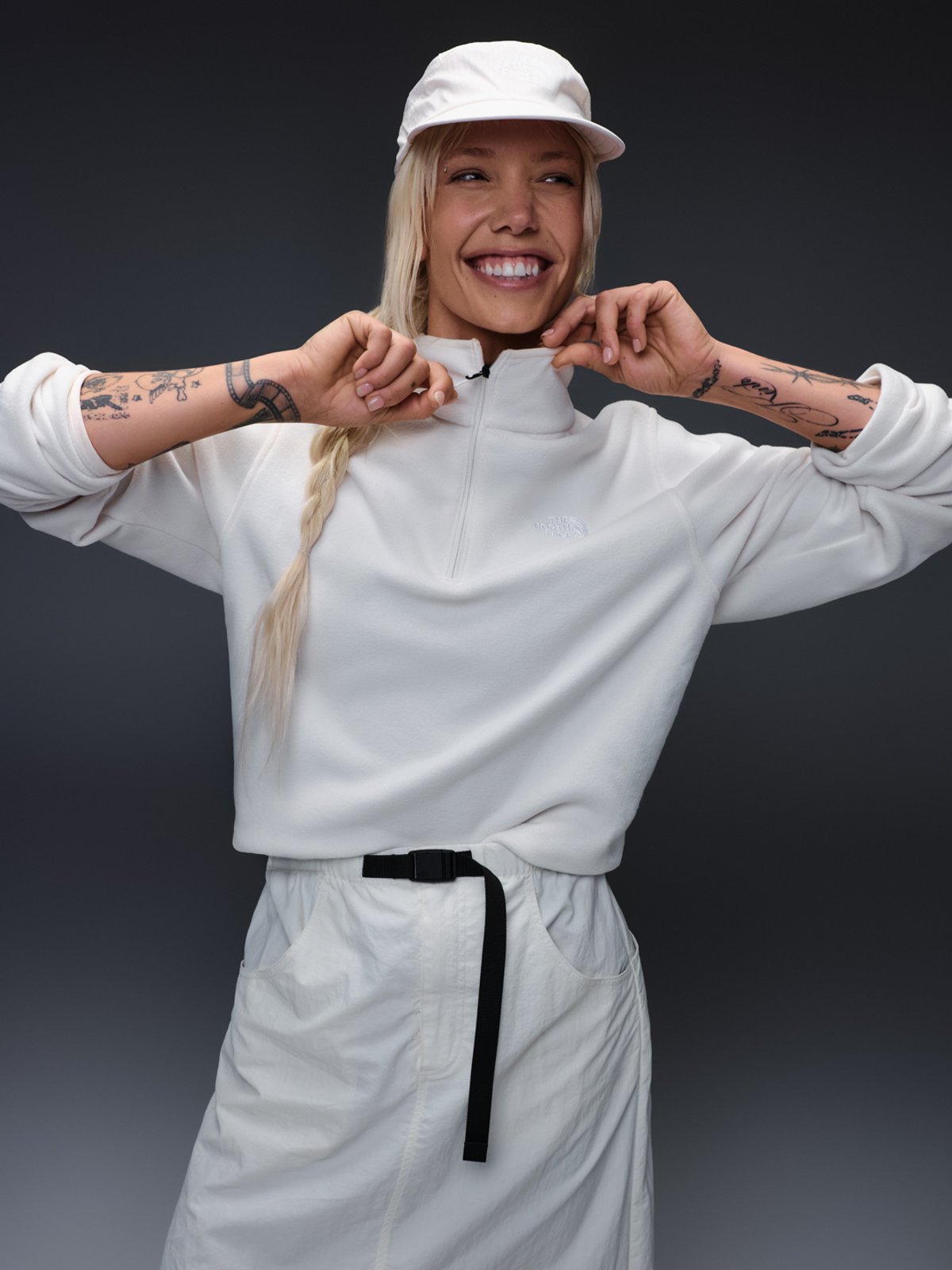 A woman wears a white The North Face quarter zip.